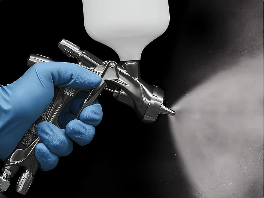 Automotive spray gun demonstrating paint atomisation and spray fan